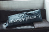 A long blue pillow with "#happy place :)" on the side.